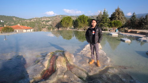 Full length of man standing on rock in lake