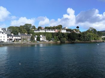 Scenic view of sea by buildings against sky