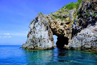 Rock formation in sea against sky