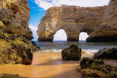 Rock formations by sea against sky