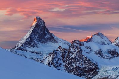 Scenic view of snowcapped mountains against sky during sunset