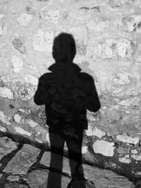 Shadow of child standing on cobblestone