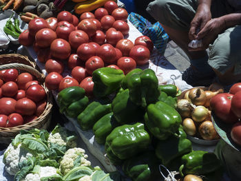 Midsection of vendor selling various vegetables at market