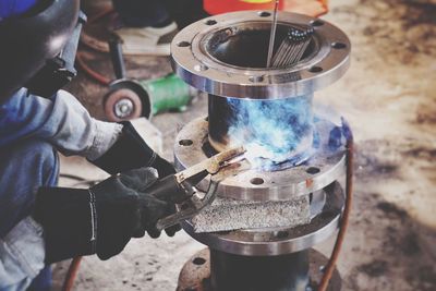 Close-up of person repairing machine part