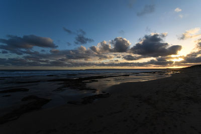 Scenic view of beach against sky during sunset