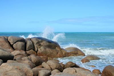 Scenic view of rocks in sea against sky