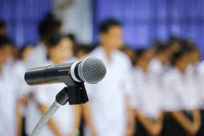 Close-up of microphone with people in background