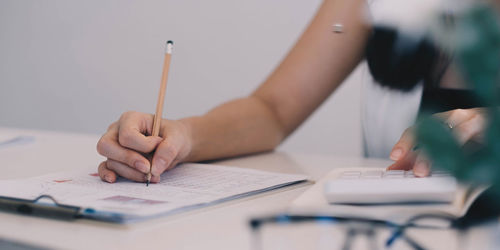 Midsection of person reading book on table