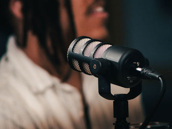 Podcast microphone close up texture with blurry person in background