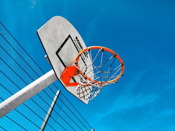 Low angle view of basketball hoop against blue sky