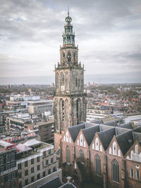 View of buildings in groningen against cloudy sky