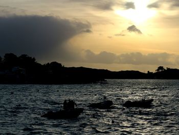 Silhouette boat in sea against sky during sunset