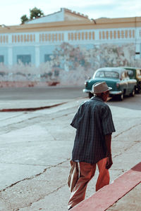 Man walking on footpath against buildings