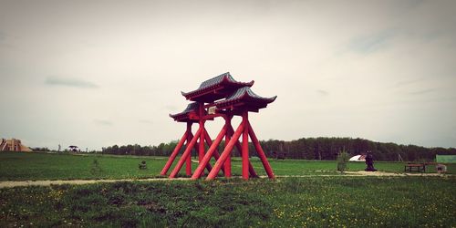 Traditional windmill on field against sky