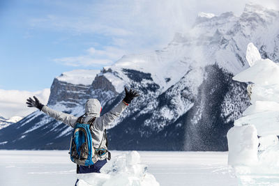 Person skiing on snow covered mountain against sky
