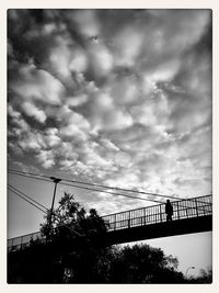 Low angle view of bridge against cloudy sky