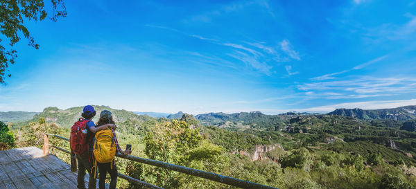 Rear view of woman walking on mountain against sky