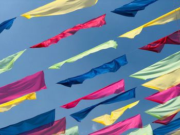 Low angle view of flag flags against blue sky