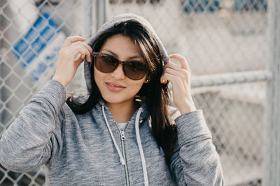 Portrait of young woman wearing sunglasses standing outdoors