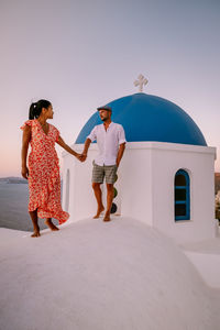 Rear view of couple kissing against clear sky