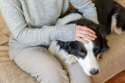 Midsection of woman petting dog