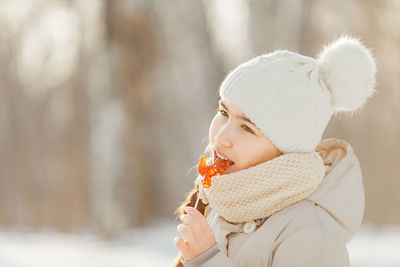 Close-up of teenage girl holding candy outdoors during winter