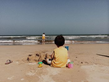 Rear view of two kids on beach