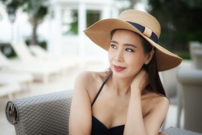 Beautiful young woman looking away while wearing hat