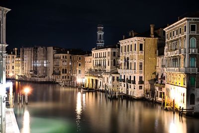 Canal passing through city buildings at night