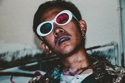 Portrait of young man wearing 3-d glasses while smoking cigarette