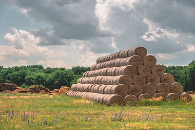 Hay bales on field against sky