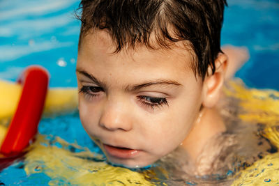 Close-up portrait of boy swimming in pool