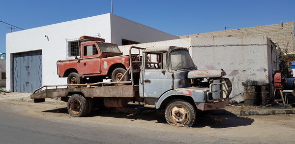 Abandoned vintage car against building