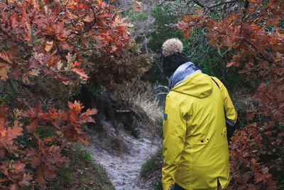 Rear view of man with autumn leaves in park