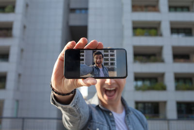 Young man using mobile phone while standing outdoors