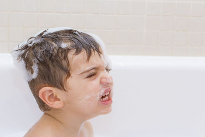 Close-up of boy in bathtub at home