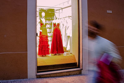 Blurred motion of woman walking by window of building