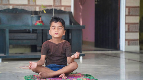 Asian child doing exercise on platform outdoors. healthy lifestyle. yoga boy.