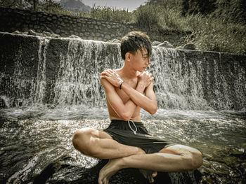 Side view of shirtless man in water