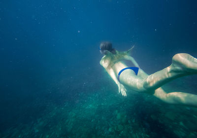 Girl swims underwater in the black sea