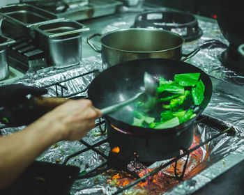 Cropped image of person preparing food in kitchen