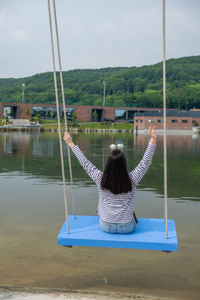 Rear view of woman swinging at playground