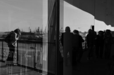 Reflection of man and woman standing on mirror