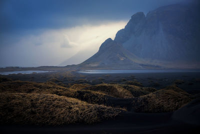 Scenic view of sea and mountains against sky