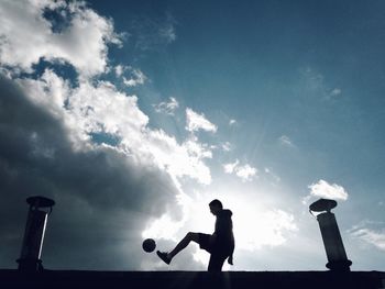 Side view of man paying soccer on building terrace