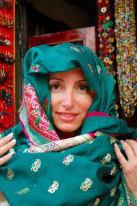 Portrait of smiling young woman wearing scarf at market