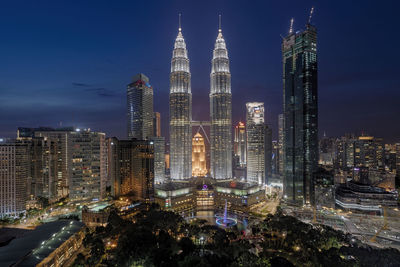 Illuminated cityscape against sky at night