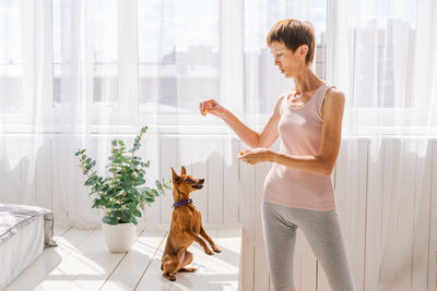 Woman practicing exercising with dog to enjoying and relaxing with yoga. spend