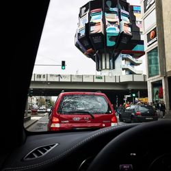 Cars on city street against sky