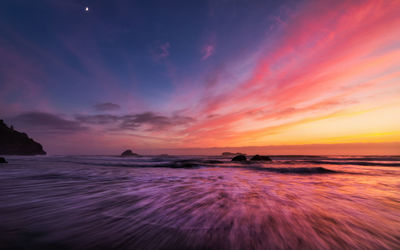 Scenic view of sea against romantic sky at sunset